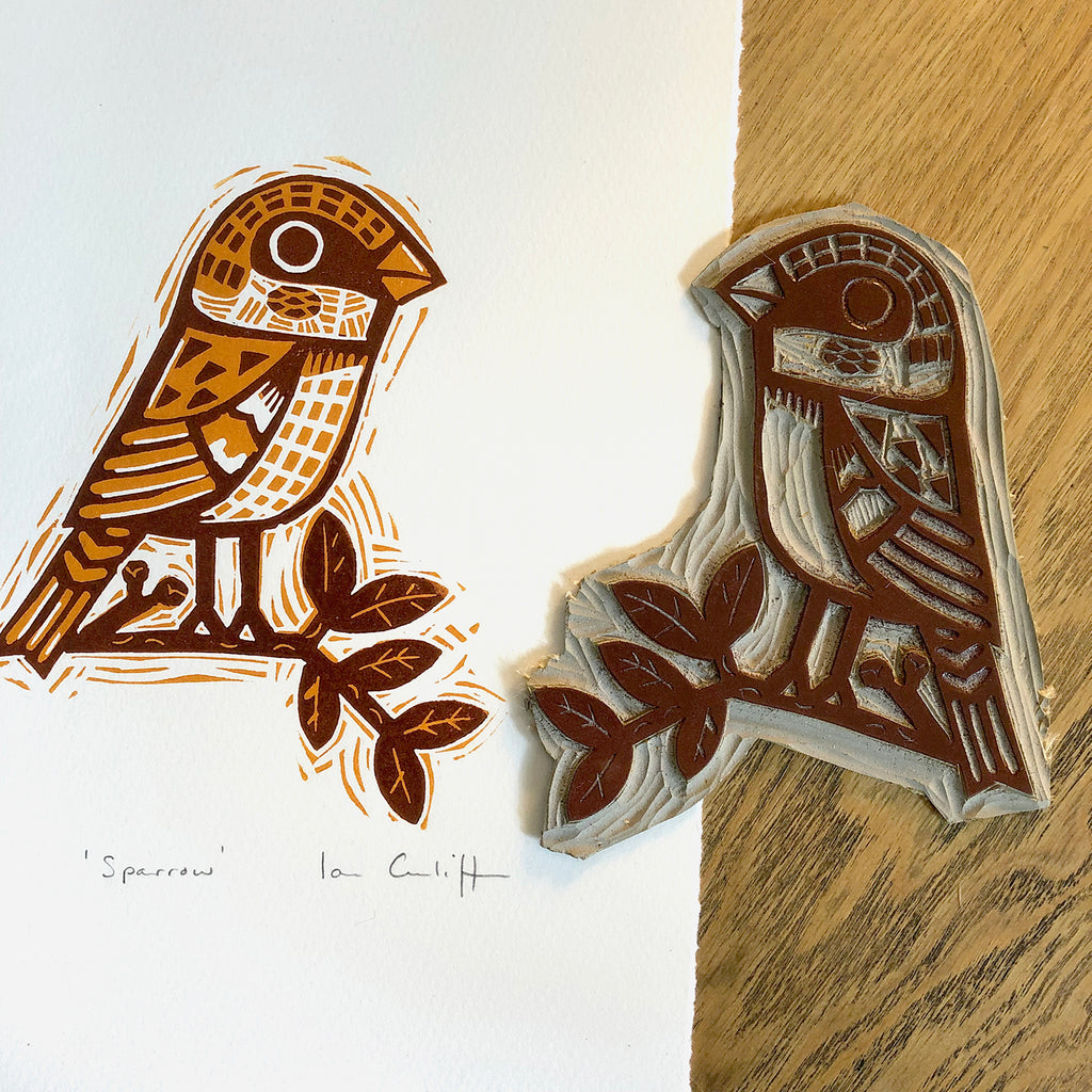 linocut sparrow bird design block print on a wooden surface
