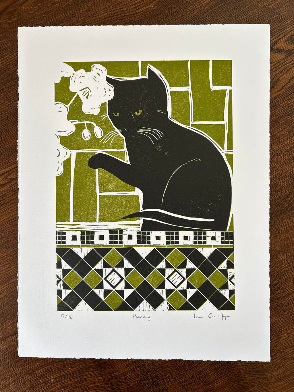 Print of a black cat sitting on a geometric patterned background